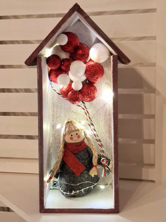 Wooden house with illuminated Christmas figure.