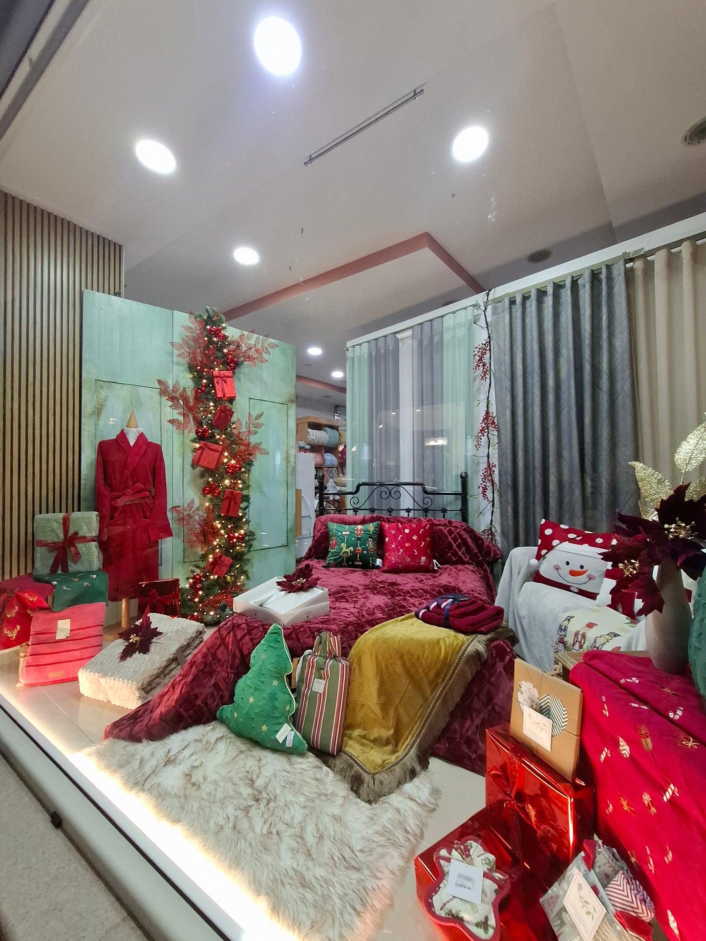 Διακόσμηση χριστουγεννιάτικης βιτρτίνας σε κατάστημα με λευκά είδη